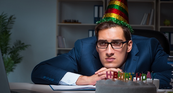 Sad businessman with a birthday hat on