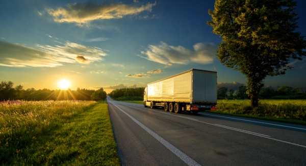 Truck driving on a highway at sunset